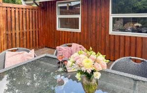 a table with a vase of flowers and two glasses of wine at 2 Bedroom Nice Home In Stenlille in Stenlille