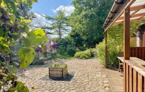 a garden with a stone walkway with a wooden deck at 2 Bedroom Nice Home In Stenlille in Stenlille +12 photos
