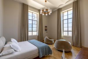 a bedroom with a bed and two windows at Hôtel du Parc in Arles