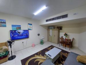a living room with a table and a television in it at Friends Hotel Apartments in Ajman  +6 photos