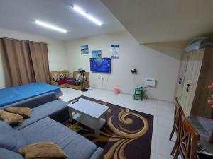 a living room with a blue couch and a table at Friends Hotel Apartments in Ajman 