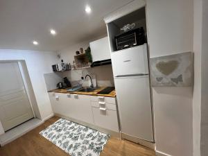 a small kitchen with a refrigerator and a sink at Entre Paris et Normandie in Mantes-la-Ville +6 photos