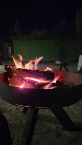 a fire in a grill with flames at Aromas de Cafayate in Cafayate