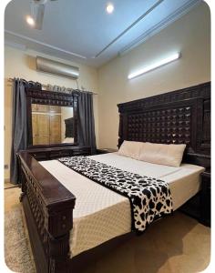 a bedroom with a large wooden bed in a room at 4Bdr Spacious Hill View Central E 11 TV Netflix in Islamabad