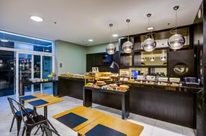 a restaurant with a counter and tables and chairs at Aera Rio de Janeiro Copacabana in Rio de Janeiro