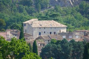 a group of houses on a hill with trees at Ancienne eglise in Vallérargues