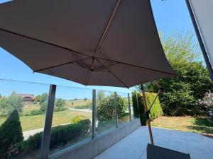 a large umbrella sitting on a chair in front of a window at appartement cosy in Tafers