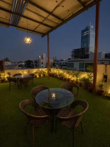 a patio with a glass table and chairs and lights at Elite Creek Clifton in Karachi