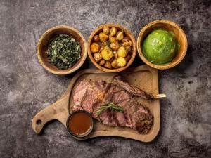 a cutting board with a steak and some bowls of vegetables at Mercure Nairobi Upper Hill in Nairobi