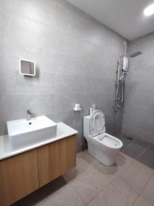 a bathroom with a toilet and a sink and a shower at Hann's Avenue Suites - Heart of Sibu - Free Parking in Sibu +6 photos