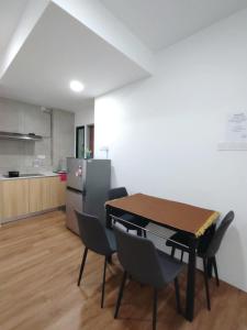 a dining room with a table and chairs and a kitchen at Hann's Avenue Suites - Heart of Sibu - Free Parking in Sibu