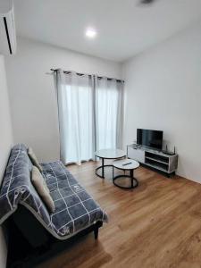 a living room with a bed and a table at Hann's Avenue Suites - Heart of Sibu - Free Parking in Sibu