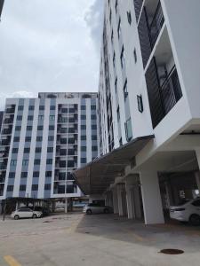 a large building with cars parked in front of it at Hann's Avenue Suites - Heart of Sibu - Free Parking in Sibu