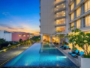 a swimming pool in front of a building at Grand Mercure Solo Baru in Solo