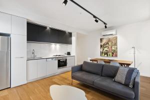 a living room with a couch and a table at District Apartments Fitzroy in Melbourne