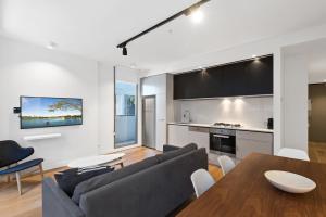 a living room with a couch and a table at District Apartments Fitzroy in Melbourne