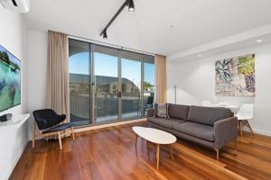 a living room with a couch and a table at District Apartments Fitzroy in Melbourne
