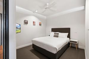 a bedroom with a bed and a ceiling fan at District Apartments Fitzroy in Melbourne