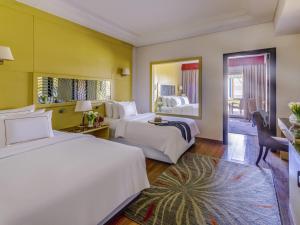 a hotel room with two beds and a mirror at Rixos Premium Seagate in Sharm El Sheikh