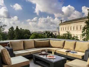 a patio with a couch and tables on a balcony at Rixos Pera Istanbul - Nickelodeon Play Access in Istanbul