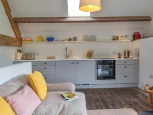 a living room with a couch and a kitchen at The Granary - Uk50401 in Llanstephan