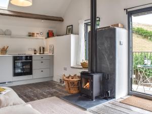 a fireplace in a living room with a stove at The Granary - Uk50401 in Llanstephan