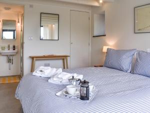 a bed with a tray of towels and a cup on it at The Granary - Uk50401 in Llanstephan +8 photos