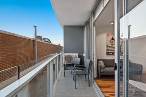 a balcony with chairs and a couch on a building at District Apartments Fitzroy in Melbourne