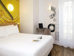 a bedroom with a white bed and a desk with a laptop at ibis Styles Marseille Gare Saint-Charles in Marseille +52 photos