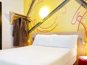a bedroom with a white bed and a wall with graffiti at ibis Styles Marseille Gare Saint-Charles in Marseille