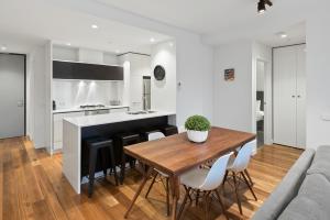 a kitchen and dining room with a wooden table at District Apartments Fitzroy in Melbourne