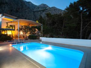 a swimming pool in front of a house at Villa Ana in Makarska