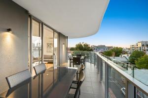 uma varanda com cadeiras e mesas num edifício em District Apartments Fitzroy em Melbourne