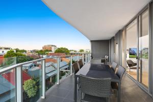 a balcony with a table and chairs on it at District Apartments Fitzroy in Melbourne