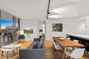 a living room and dining room with a table and chairs at District Apartments Fitzroy in Melbourne