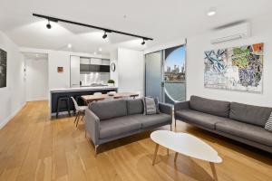 a living room with a couch and a table at District Apartments Fitzroy in Melbourne