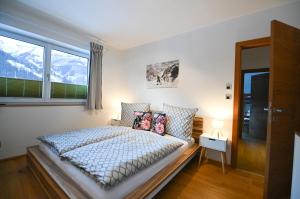 a bedroom with a bed and a large window at Chalet Creatina by we rent, NATIONALPARK CARD INCLUDED in Rauris
