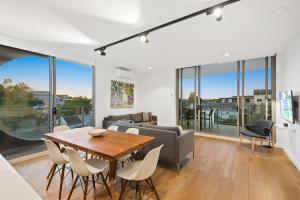 a living room with a table and chairs and a couch at District Apartments Fitzroy in Melbourne