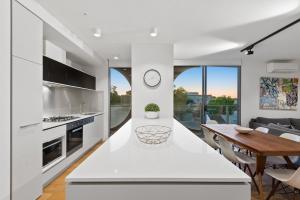 a kitchen with a white counter top and white cabinets at District Apartments Fitzroy in Melbourne