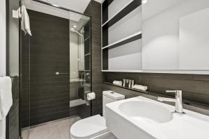 a bathroom with a white sink and a toilet at District Apartments Fitzroy in Melbourne