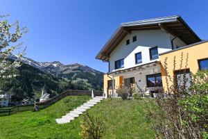 a house on a hill with mountains in the background at Chalet Creatina by we rent, NATIONALPARK CARD INCLUDED in Rauris