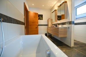 a bathroom with a large tub and a sink at Chalet Creatina by we rent, NATIONALPARK CARD INCLUDED in Rauris +35 photos