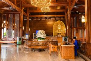 a woman sitting at a table in a lobby at Le' VIVA Resort Mui Ne in Mui Ne