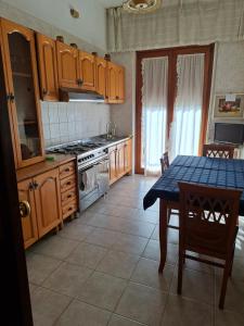 a kitchen with wooden cabinets and a table with a blue table cloth at la casa di LILLY con wi fi in Avellino