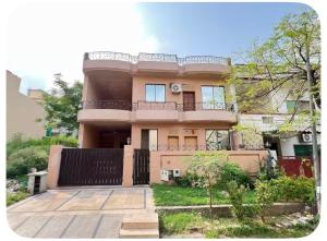 a large pink house with a fence in front of it at 4Bdr Spacious Hill View Central E 11 TV Netflix in Islamabad