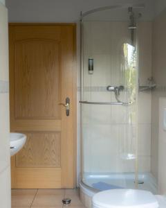 a bathroom with a shower and a toilet and a sink at Fliederhof Stücken Apartments bei Potsdam in Michendorf +38 photos