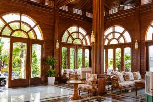 a lobby with large windows and chairs and a table at Le' VIVA Resort Mui Ne in Mui Ne