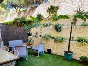 a patio with chairs and a table and a wall with plants at Marta Beach House - Caños De Meca in Los Caños de Meca