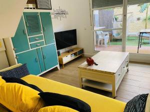 a living room with a yellow couch and a tv at Marta Beach House - Caños De Meca in Los Caños de Meca