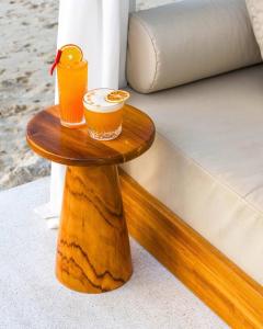 a wooden table with two drinks on top of a bed at Rockstar Beach Apartments in Bangrak Beach